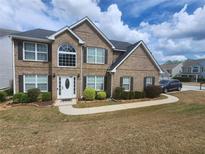 Charming two-story brick home featuring a manicured front yard and welcoming entrance at 543 Walnut Way, Palmetto, GA 30268
