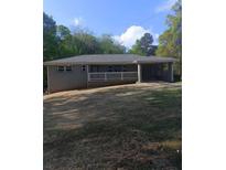 A single story home with a white picket fence, attached carport and green lawn at 2598 Miriam Ln, Decatur, GA 30032