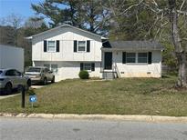 Charming two-story home featuring a manicured front lawn, classic black shutters, and convenient driveway parking at 579 Wexwood Dr, Riverdale, GA 30274