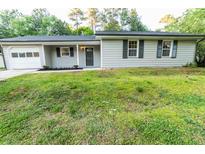 Charming single story home with light gray siding, black shutters and trim at 945 Navajo Trl, Covington, GA 30016