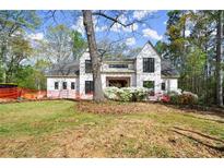 New home boasts modern design, black-trimmed windows, a manicured lawn, and blooming flowers at 1430 Oconee Ne Pass, Brookhaven, GA 30319