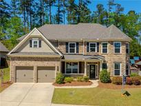 Charming two-story home featuring a brick and stone facade, well-manicured lawn, and a two-car garage at 241 Haney Rd, Woodstock, GA 30188