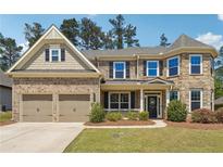 Charming brick home with a two-car garage and manicured front lawn, perfect for suburban living at 241 Haney Rd, Woodstock, GA 30188