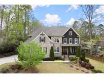 Beautiful two-story brick home with manicured lawn and mature trees at 383 Indian Hills Trl, Marietta, GA 30068
