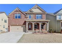 Beautiful two-story brick home with a stone porch and arched entryways at 7130 Rocking Horse Ln, Cumming, GA 30040