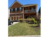 Charming two-story home with brick accents, an attached garage, and a cozy second-story balcony at 1668 Scenic Pines Dr, Lawrenceville, GA 30044
