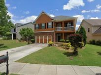 Charming two-story home with a balcony, brick accents, and well-maintained landscaping at 1668 Scenic Pines Dr, Lawrenceville, GA 30044