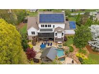 Expansive backyard featuring a pool, spa, screened porch, and solar panels for energy efficiency at 332 Chaffin Rd, Roswell, GA 30075