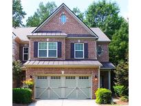 Charming two-story brick home featuring a well-manicured lawn and an attached two-car garage at 11212 Snowy Owl Ln, Alpharetta, GA 30022