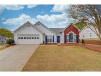 Charming one-story home featuring a two-car garage, blue shutters, and a well-maintained front yard with mature trees at 1193 Colony Creek Ct, Lawrenceville, GA 30043