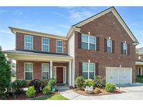 Charming two-story brick home with manicured landscaping and a welcoming front porch at 3798 Broadleaf Walk, Snellville, GA 30039