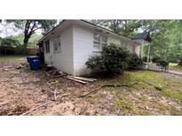 View of a white single story home with a covered front porch and landscape at 6194 Polly Anna Se Ave, Covington, GA 30014