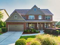 Charming two-story brick home with a well-manicured lawn, covered porch, and two-car garage at 2694 Dawning Day Dr, Dacula, GA 30019