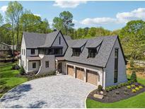 Stunning brick home featuring a three-car garage and a beautifully paved driveway at 100 Maison Ct, Roswell, GA 30076