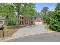 Charming two-story brick home featuring a large driveway and well-maintained landscaping at 3130 Crestmont Nw Way, Kennesaw, GA 30152