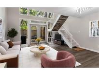 Inviting living room features large windows, a staircase, and an open floor plan perfect for entertaining at 41 Cantey Nw Pl, Atlanta, GA 30327