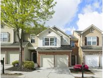 Charming townhome featuring a brick facade, attached garage, and well-manicured landscaping at 5556 Cascade Sw Run, Atlanta, GA 30336