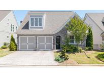 Charming home featuring a stone facade, well-manicured lawn, and a two-car garage at 416 Loblolly St, Woodstock, GA 30188