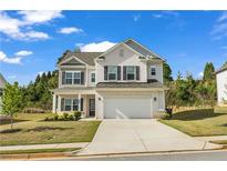 Charming two-story home with a brick facade, black shutters, attached two car garage and well maintained lawn at 5140 Woodline View Cir, Auburn, GA 30011