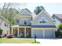 Charming two-story home with a covered front porch, stone accents, and a two-car garage at 307 Downing Creek Trl, Canton, GA 30114