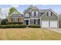Charming two-story home with a manicured lawn and a two-car garage and stone detailing at 902 Brumley Nw Ln, Kennesaw, GA 30152