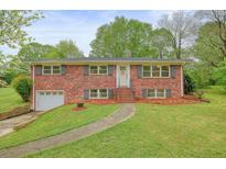 Traditional brick home with a well-maintained lawn and mature trees at 2449 Fraser Rd, Marietta, GA 30066