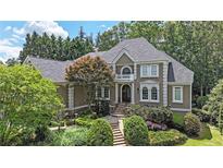 Stately two-story home with mature landscaping, a walkway, and elegant architectural details at 3915 Merriweather Woods, Johns Creek, GA 30022