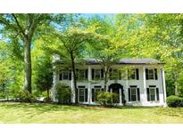 Charming two-story white home featuring a black roof, black shutters and a beautiful lawn at 909 Otter Ne Way, Marietta, GA 30068