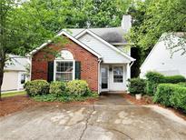 Charming brick-and-vinyl home with lush landscaping and a cozy front porch at 645 Crossbridge Aly, Johns Creek, GA 30022