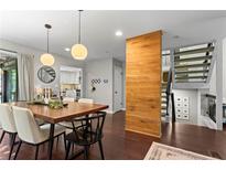 Bright dining room features a wooden table, modern light fixtures, and an open staircase at 3085 Balearic Se Dr, Marietta, GA 30067