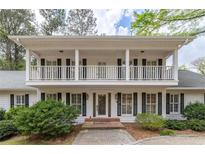 Charming two-story home with a welcoming front porch and beautifully manicured landscaping at 1800 East Gate Dr, Smoke Rise, GA 30087
