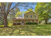 Charming two-story home with a brick foundation, covered porch, and a lush, green lawn at 4819 Elam Rd, Stone Mountain, GA 30083