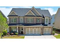 Beautiful two-story home features brick accents, manicured lawn and a three-car garage at 715 Laura Jean Ct, Buford, GA 30518