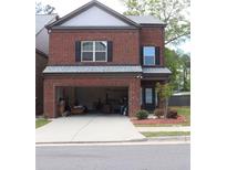 Two-story brick home with a two-car garage and small front yard featuring nice landscaping at 4265 Almanor Cir, Norcross, GA 30071