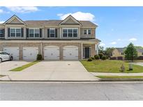 Charming townhome featuring a brick facade, individual garages, and well-maintained landscaping at 7200 Brigidoon Rose, Douglasville, GA 30134