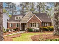 Charming brick home with lush landscaping, stone pathway, and inviting front porch at 883 Wildwood Ne Rd, Atlanta, GA 30324