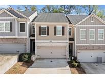 Charming townhome featuring a beige exterior, a two-car garage, and a well-maintained front yard at 3016 Creekside Overlook Way, Austell, GA 30168