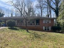 Charming brick ranch-style home with covered parking and a cozy front porch in a serene, tree-lined setting at 2333 Oakridge Ct, Decatur, GA 30032