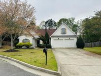 Charming single-story home featuring a two-car garage and a well-manicured front yard with mature landscaping at 2520 Legend Mill Run, Dacula, GA 30019