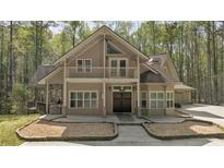 Charming two-story home with a balcony, covered porch, mature trees, and a well-manicured front yard at 3800 Macland Rd, Hiram, GA 30141