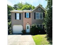 Charming two-story home with a well-maintained lawn and an attached one car garage at 6715 Roscommon Dr, Austell, GA 30168