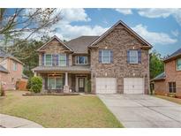 Charming two-story brick home with a well-manicured lawn and attached two-car garage at 1633 Park Hollow Ln, Lawrenceville, GA 30043