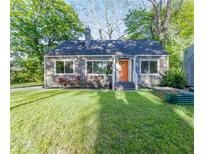 Charming home featuring a manicured lawn, bright orange front door, and inviting curb appeal at 22 Vinson Se Dr, Atlanta, GA 30317