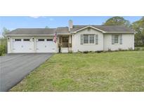 Charming painted brick ranch with an attached two car garage and manicured lawn at 5125 Dahlonega Hwy, Cumming, GA 30028
