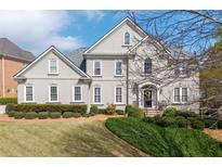 Elegant two-story home with a manicured lawn and lush landscaping at 5334 Lake View Clb, Atlanta, GA 30338