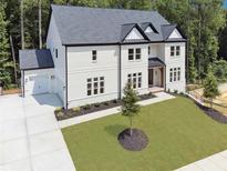 Stunning two-story painted brick home with a dark roof, lush lawn, and an attached two car garage at 3930 Clifton Hill Court #15, Cumming, GA 30040