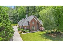 Beautiful brick home featuring a well-manicured lawn and mature trees, offering great curb appeal at 1418 Brighton Pl, Loganville, GA 30052