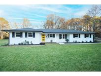 Charming ranch home featuring freshly painted white brick and a bright yellow front door at 144 Morning Creek Rd, Jonesboro, GA 30238