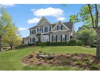 Beautiful two-story home featuring a landscaped yard and classic architectural details at 295 Sagamore Nw Cv, Sugar Hill, GA 30518