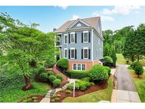 Charming two-story home with a landscaped front yard, blue siding, black shutters and a well-manicured lawn at 1456 Hedgewood Nw Ln, Kennesaw, GA 30152